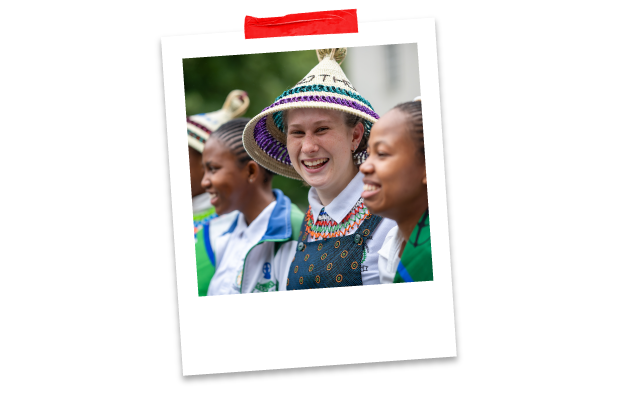 Llinell o bobl yn gwenu a chwerthin. Mae rhai yn gwisgo hetiau Basotho (mokorotlo).